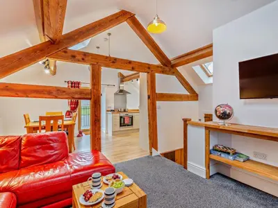 a living room with a red couch and a table at 2 Bed in Craven Arms oc-94099 in Clun