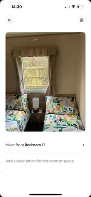 a small room with two beds and a window at AJ’s Caravan Hire in Aberystwyth