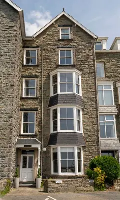 a large brick house with white windows at The Belmont Barmouth in Barmouth