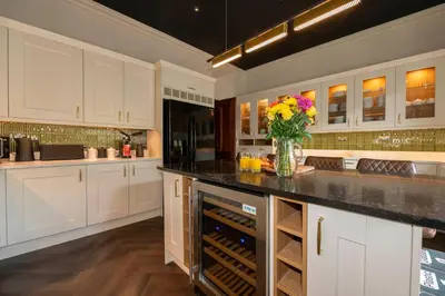 a kitchen with white cabinets and a vase of flowers at The Belmont Barmouth in Barmouth