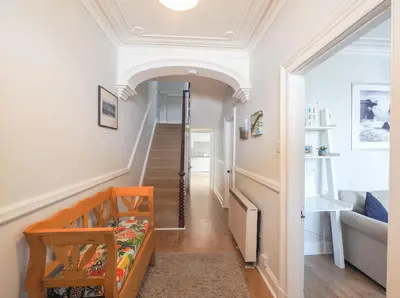 a hallway with a stairway leading to a living room at Brodawel New Quay in New Quay