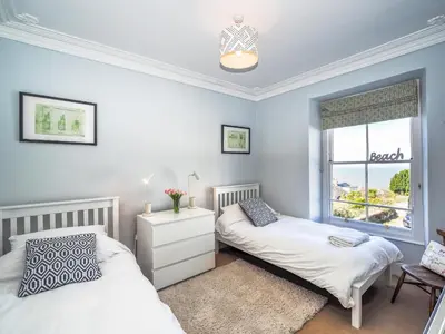 a bedroom with two beds and a window at Brodawel New Quay in New Quay