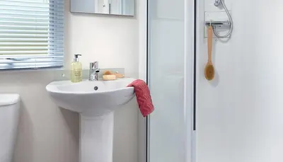 a bathroom with a white sink and a shower at WH - Smugglers Cove 03 in Aberaeron