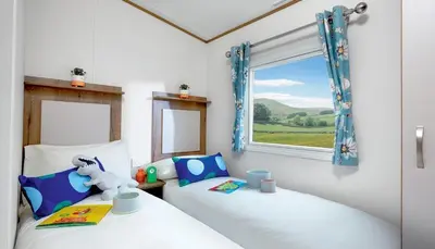 two twin beds in a room with a window at WH - Smugglers Cove 03 in Aberaeron