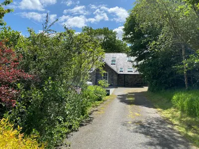 a dirt road leading to a stone house at Ty Cellin Tregaron in Ystrad-Meurig