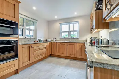 a large kitchen with wooden cabinets and appliances at 4 Bed in Rhayader oc-m28919 in Nantmel