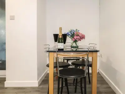 a table with a bottle of champagne and some flowers at Henllys in Harlech