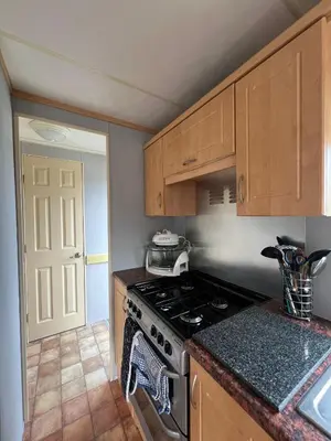 a kitchen with a stove and a counter top at Spacious 2 bedroomed mobile home in Aberystwyth