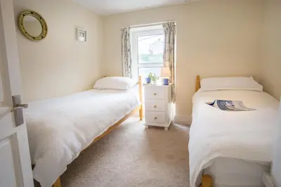 two beds in a room with a window at Ellesmere New Quay in New Quay