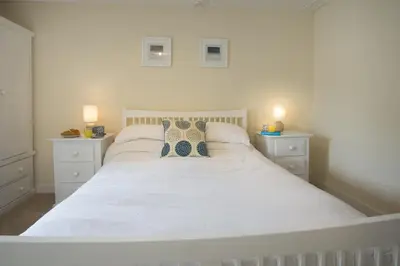 a white bed with two pillows on it in a bedroom at Ellesmere New Quay in New Quay