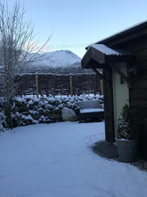 a yard covered in snow next to a house at Cabin in the hills near Dolgellau in Dolgellau