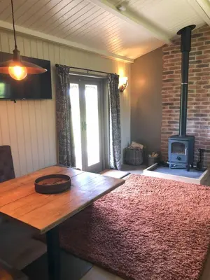 a living room with a wooden table and a fireplace at Cabin in the hills near Dolgellau in Dolgellau