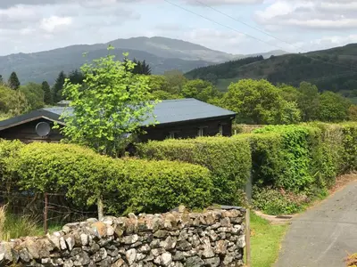 a house with a stone fence and a stone wall at Cabin in the hills near Dolgellau in Dolgellau