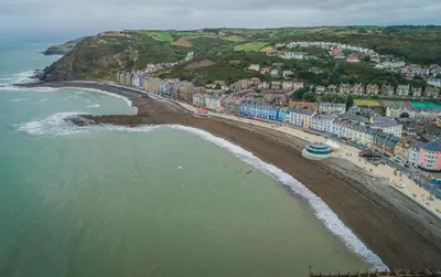 an aerial view of a beach with buildings and the ocean at Briallen Aberystwyth in Llanrhystyd