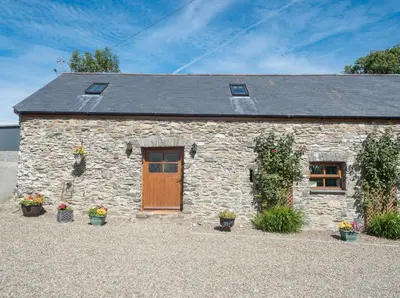 a stone house with plants in front of it at Eirlys Aberystwyth in Llanrhystyd