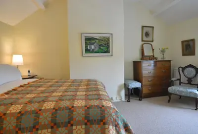 a bedroom with a bed and a dresser and a dresser at Cae Mawr Borth and Ynyslas in Scyborycoed