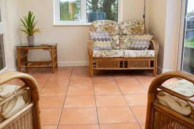 a living room with a chair and a table at Soar Cottage Aberystwyth in Aberystwyth