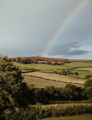 a view of a field with a rainbow in the sky at The Granary Wales in Kington