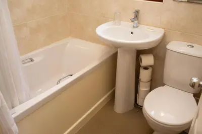 a bathroom with a sink and a toilet and a bath tub at Townhouse Aberystwyth in Aberystwyth