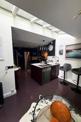 a kitchen with a table and a clock on the wall at Glandwr hall - 6 Bed - Magnificent Country House with Heated Swimming Pool & Jacuzzi in Barmouth