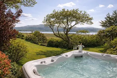 a bath tub in a garden with a view at Glandwr hall - 6 Bed - Magnificent Country House with Heated Swimming Pool & Jacuzzi in Barmouth