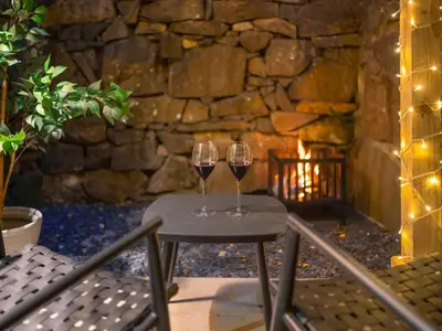 two wine glasses sitting on a table in front of a fireplace at Llety Cariad in Bala
