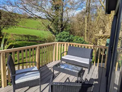 a deck with two chairs and a table and a bench at Sarn Y Glyn in Mid Wales Cambrian Mountains near Llanidloes Powys in Caersws