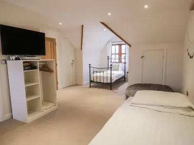 a bedroom with a bed and a tv on a wall at Anadlu in Llanbedr