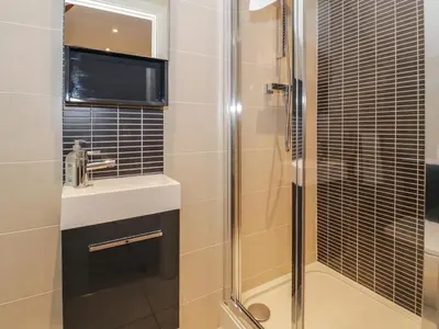 a bathroom with a shower and a sink at Anadlu in Llanbedr