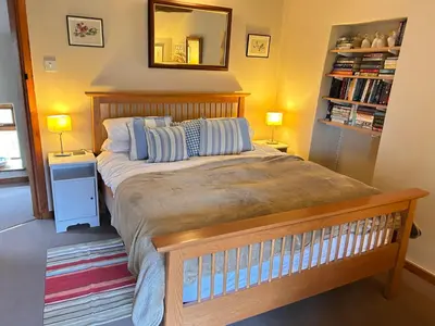 a bedroom with a bed with two lamps and a mirror at Llanerch in Bala