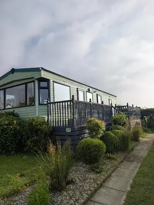 a green trailer is parked in a yard at 64 Wide Horizon in Aberaeron