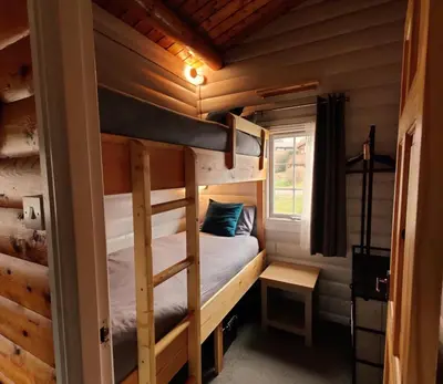 a bedroom with a bunk bed in a log cabin at Serene Snowdonia Retreat in Trawsfynydd