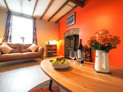 a living room with a table with a bowl of fruit at Bryndalis Aberaeron in Ciliau-Aeron
