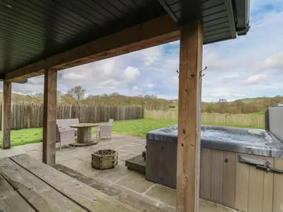 a patio with a hot tub and a table at Caban Dulas in Rhayader