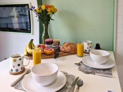 a table with two cups and plates and a vase of flowers at The Heron's Tree in Llandovery