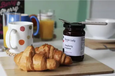 a cutting board with croissants and a jar of jam at The Kingfishers Burrow in Llandovery