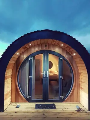 a large glass door in a circular building at The Kingfishers Burrow in Llandovery