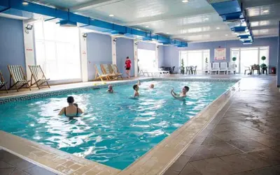 a group of children swimming in a swimming pool at No. 4 Sunny Lodge By The Sea in Aberystwyth