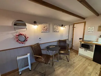 a kitchen with a table and chairs in a room at Hafod Shepherd Hut in Aberystwyth