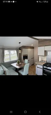 a kitchen and a living room with a table and chairs at Barmouthbay209 in Barmouth