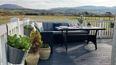 a porch with a couch and a table with plants at Barmouthbay209 in Barmouth
