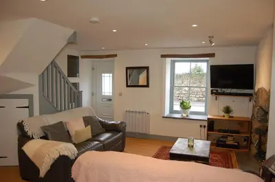 a living room with a couch and a television at Ty Del - Beautiful Home in Tywyn in Tywyn