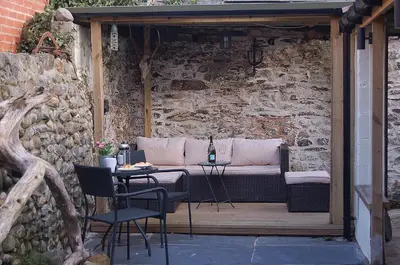 a patio with a couch and a table and chairs at Ty Del - Beautiful Home in Tywyn in Tywyn