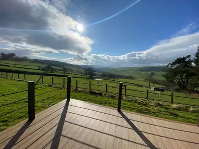a wooden boardwalk with a view of a field at The Pod Patch - Trelerney Pod in Bishops Castle