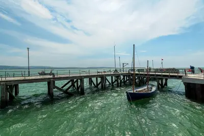 a boat is docked next to a pier at Ground Floor Sea View Apartment in Aberdyfi