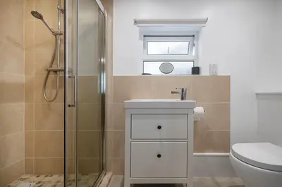 a bathroom with a shower and a sink and a toilet at Ground Floor Sea View Apartment in Aberdyfi