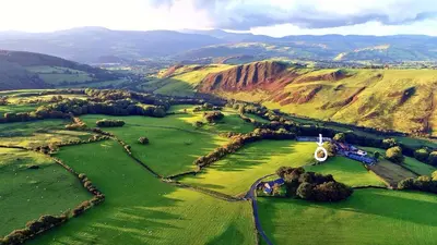 an aerial view of a golf course in the mountains at Glyndwr Way Cabin in Machynlleth