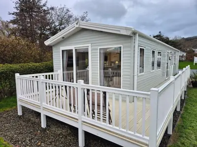 a white tiny house with a white railing at HARRIES LODGE QUAY WEST milkwood way in New Quay