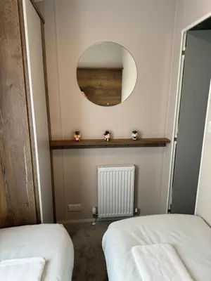 a bedroom with two beds and a mirror on the wall at Sea La Vie Lodge in New Quay