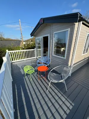 a deck with two chairs and a table and chairs at Sea La Vie Lodge in New Quay